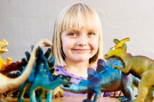 girl smiling with dinosaurs