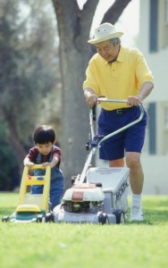 old man and little boy mowing the lawn