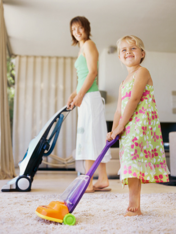 Mom and daughter vacuuming