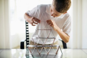 Boy building a card house