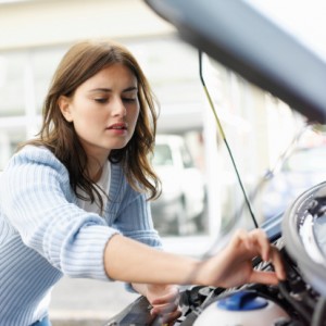 Girl fixing car engine