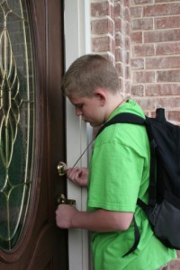 Boy unlocking front door