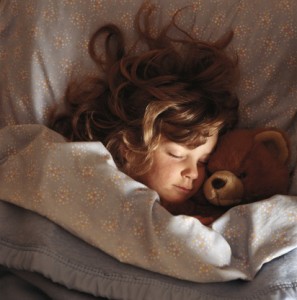 Girl sleeping with a teddy bear